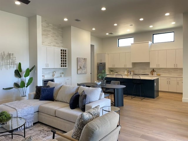 2317 Kahala Sunset Dr, Spicewood, TX 78669 - living room featuring recessed lighting, a high ceiling, visible vents, and light wood-type flooring