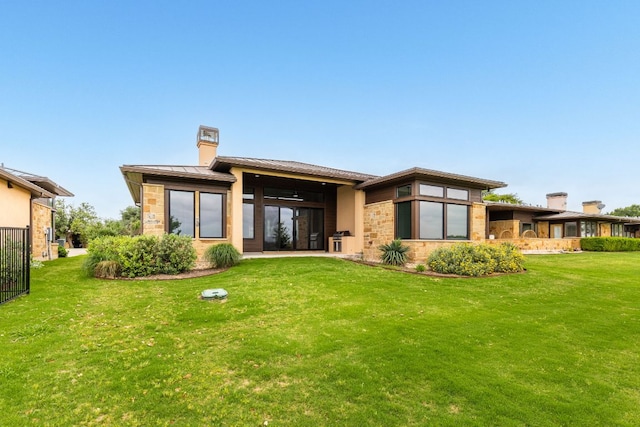 2317 Kahala Sunset Dr, Spicewood, TX 78669 - rear view of property with stone siding, a yard, a chimney, and a standing seam roof