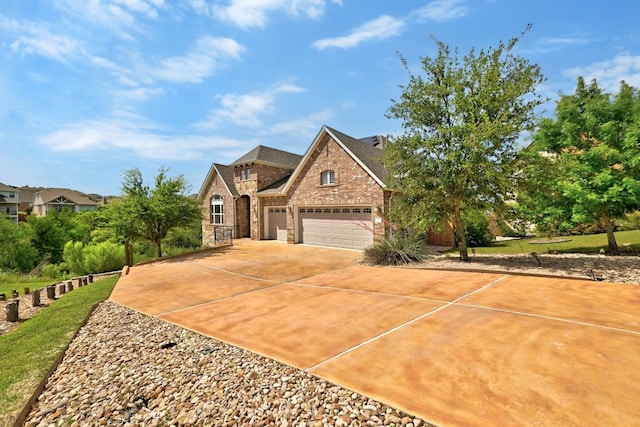 traditional-style house with an attached garage, concrete driveway, brick siding, and stone siding