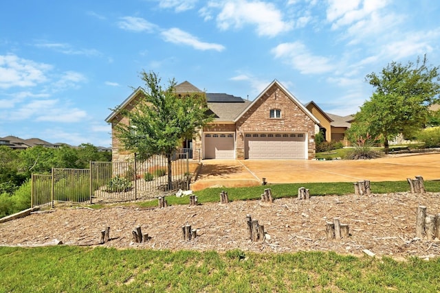 craftsman-style home with fence, an attached garage, stone siding, solar panels, and driveway