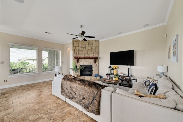 living area featuring visible vents, crown molding, baseboards, a stone fireplace, and ceiling fan