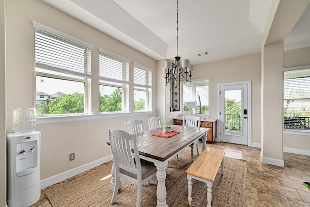 dining area with baseboards, a notable chandelier, and stone finish floor