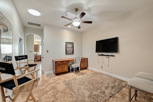 home office with arched walkways, ceiling fan, visible vents, and baseboards