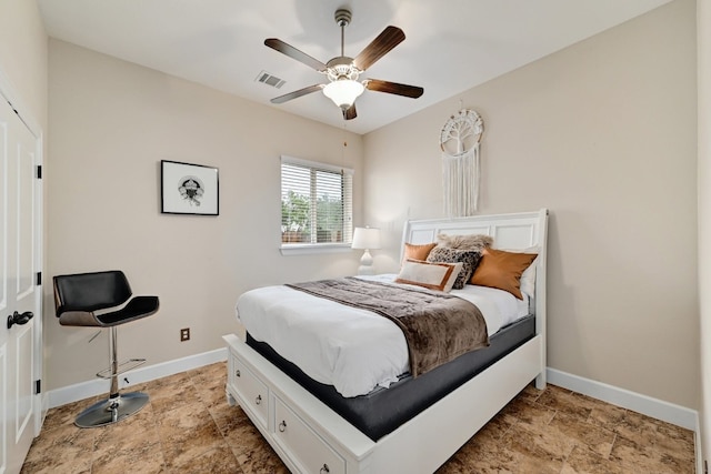 bedroom with stone finish floor, baseboards, ceiling fan, and visible vents