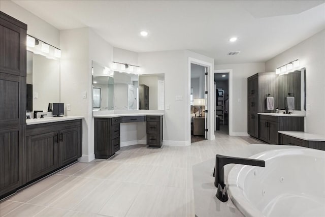 full bath with recessed lighting, visible vents, two vanities, and a jetted tub