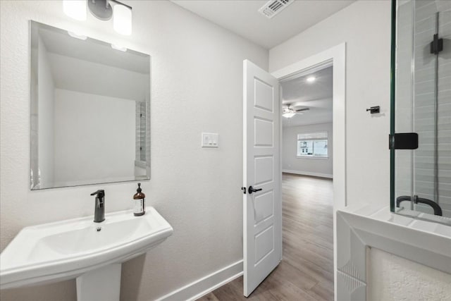 bathroom with a ceiling fan, visible vents, wood finished floors, a sink, and baseboards
