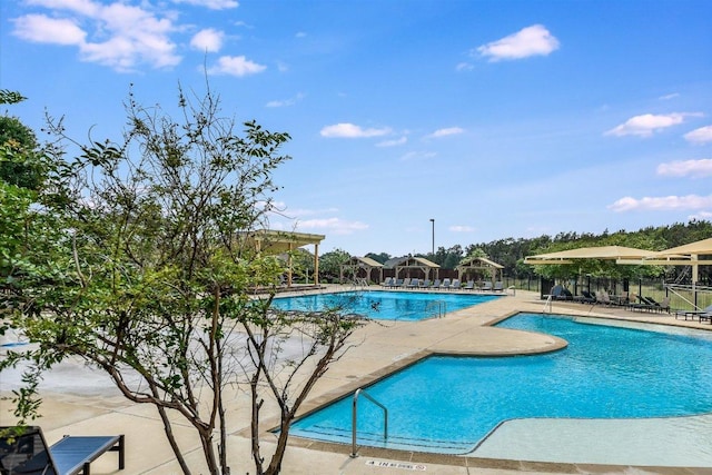 community pool with a patio and fence