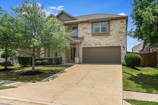 traditional-style home with driveway, roof with shingles, fence, an attached garage, and stone siding