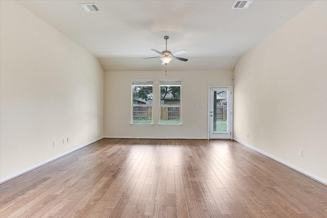 spare room with baseboards, ceiling fan, visible vents, and wood finished floors