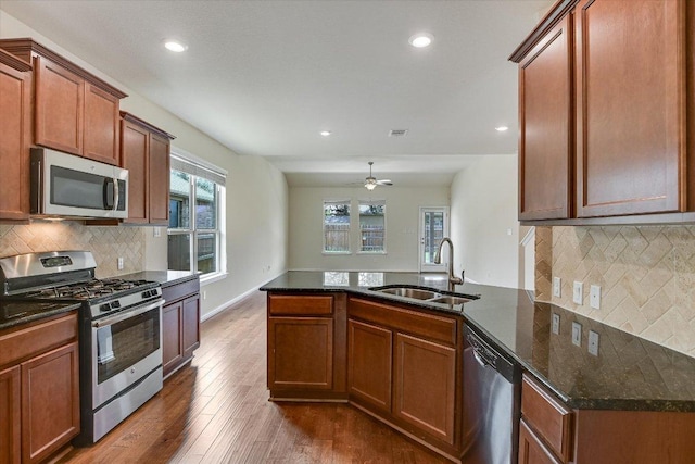 kitchen featuring recessed lighting, a sink, appliances with stainless steel finishes, and a peninsula
