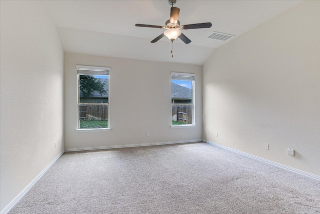 carpeted spare room with a wealth of natural light, a ceiling fan, lofted ceiling, and visible vents