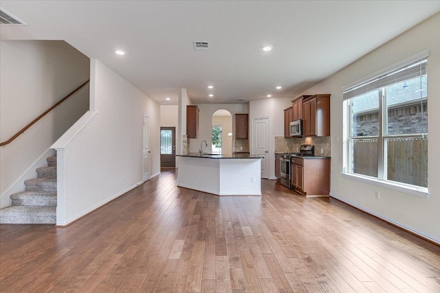 3639 Hermann St, Round Rock, TX 78681 - kitchen featuring visible vents, dark countertops, appliances with stainless steel finishes, arched walkways, and hardwood / wood-style flooring