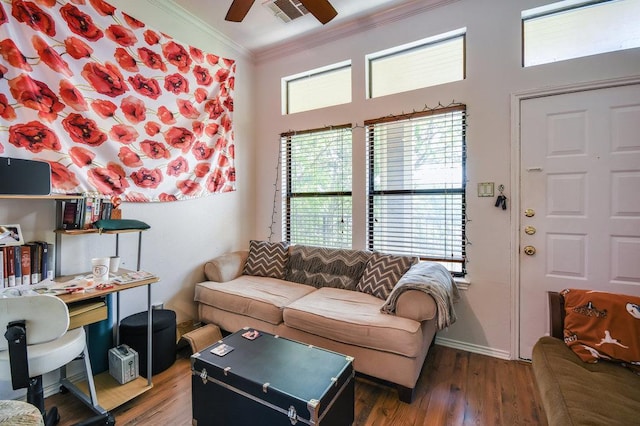 living room with crown molding, ceiling fan, wood finished floors, and visible vents