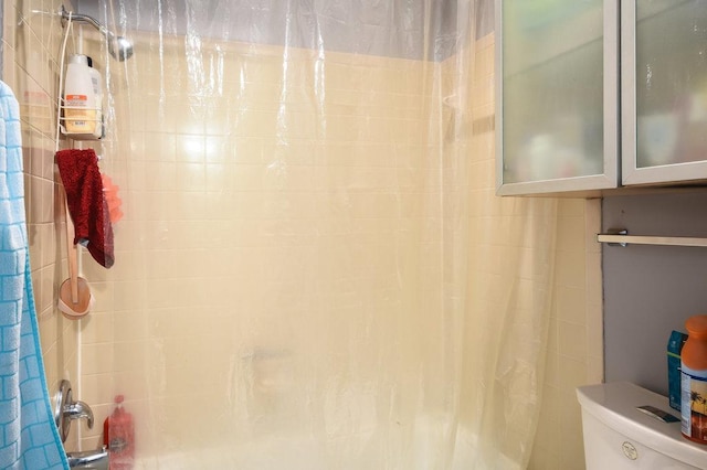 bathroom with toilet and shower / bath combination with curtain