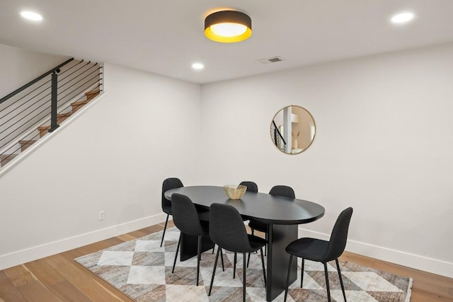 dining space with visible vents, stairs, wood finished floors, baseboards, and recessed lighting