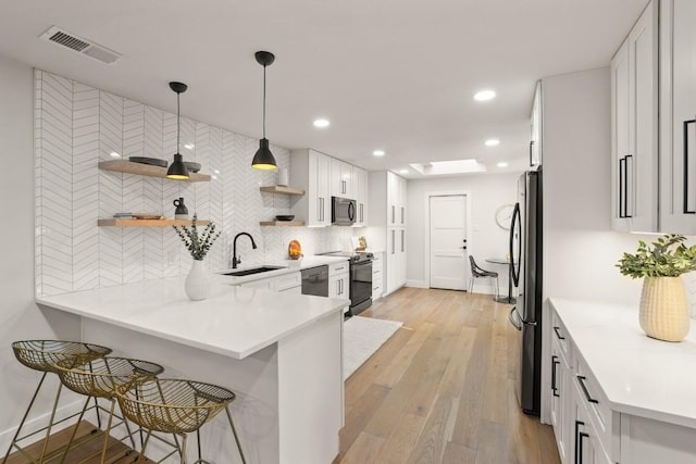 kitchen with visible vents, open shelves, white cabinets, a sink, and stainless steel appliances