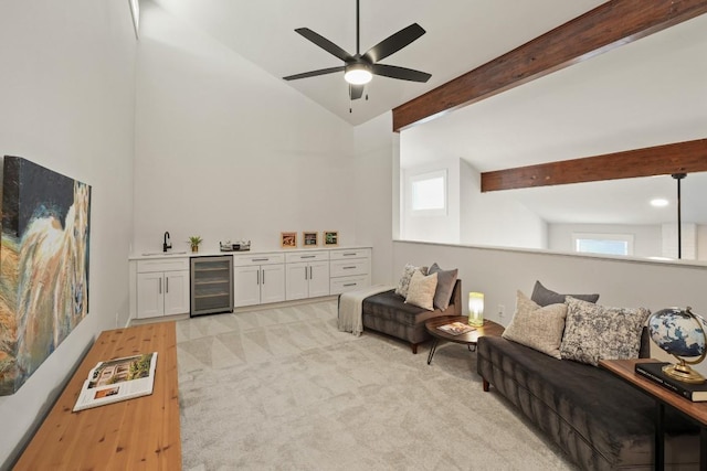 living room featuring ceiling fan, a dry bar, beam ceiling, high vaulted ceiling, and wine cooler