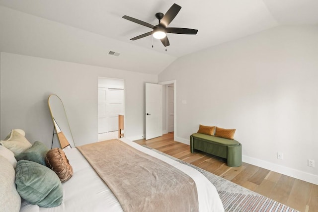 bedroom featuring a ceiling fan, baseboards, wood finished floors, lofted ceiling, and visible vents