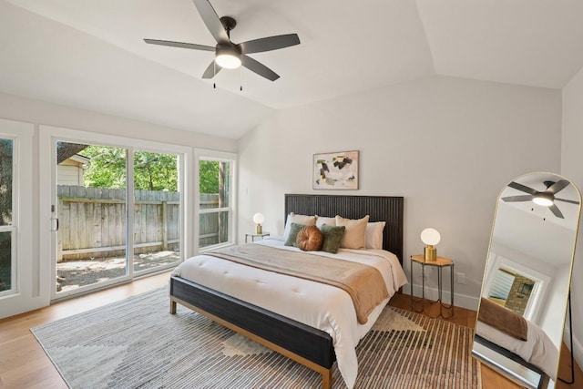 bedroom with light wood-style floors, access to outside, a ceiling fan, and vaulted ceiling