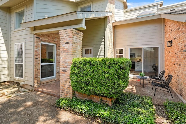 property entrance featuring brick siding
