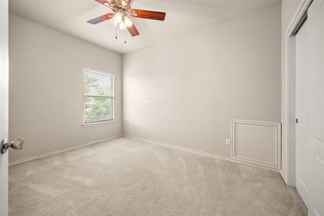 carpeted spare room with baseboards and ceiling fan