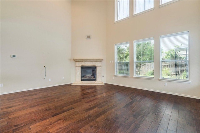 3012 Centennial Olympic Park, Austin, TX 78732 - unfurnished living room featuring dark wood finished floors, a premium fireplace, a high ceiling, and baseboards