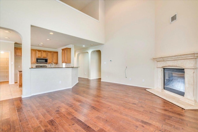 3012 Centennial Olympic Park, Austin, TX 78732 - unfurnished living room featuring light wood-style flooring, a fireplace, recessed lighting, crown molding, and baseboards