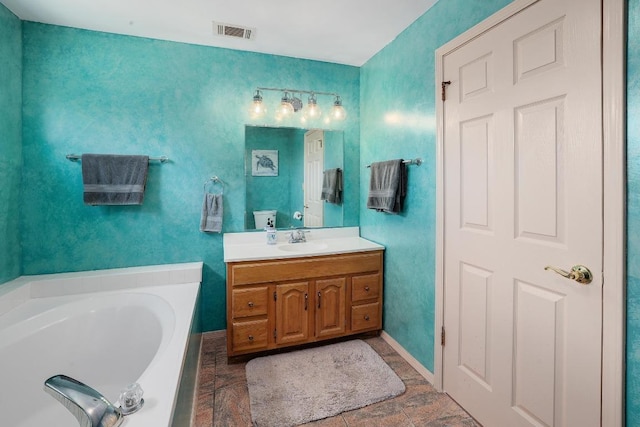 full bathroom featuring vanity, baseboards, a garden tub, and visible vents