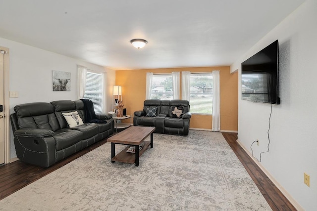 living area with baseboards and wood finished floors