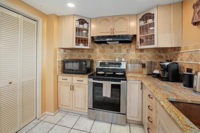 kitchen with black microwave, light brown cabinetry, stainless steel range with electric stovetop, light tile patterned floors, and under cabinet range hood