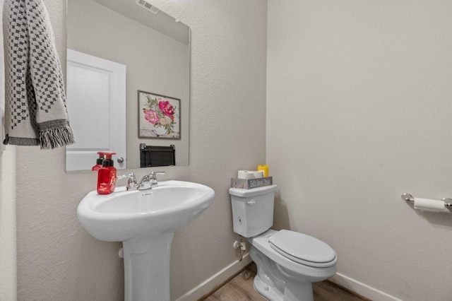 505 Pearly Eye Dr Unit B, Pflugerville, TX 78660 - half bath with visible vents, wood finished floors, toilet, baseboards, and a sink