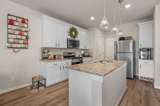 505 Pearly Eye Dr Unit B, Pflugerville, TX 78660 - kitchen with appliances with stainless steel finishes, tasteful backsplash, wood finished floors, a sink, and white cabinets