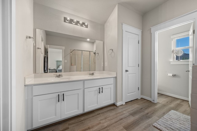 505 Pearly Eye Dr Unit B, Pflugerville, TX 78660 - full bathroom featuring a sink, a shower stall, double vanity, and wood finished floors