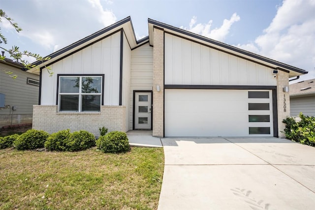 view of front of house featuring brick siding, a garage, board and batten siding, and concrete driveway