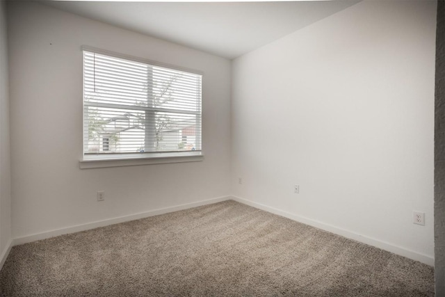 carpeted spare room with baseboards