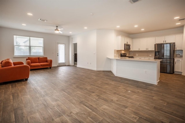 kitchen featuring decorative backsplash, a ceiling fan, appliances with stainless steel finishes, light countertops, and open floor plan