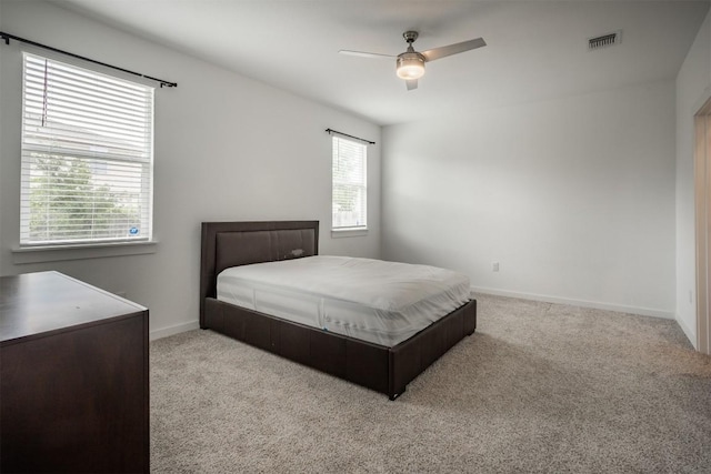 bedroom with a ceiling fan, baseboards, visible vents, and carpet