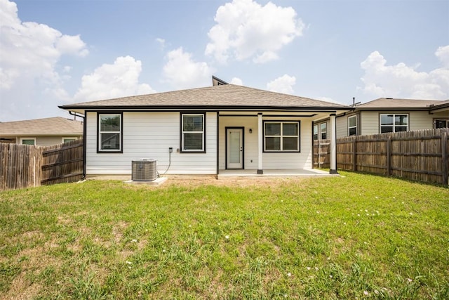 rear view of house featuring a lawn, a fenced backyard, and central air condition unit