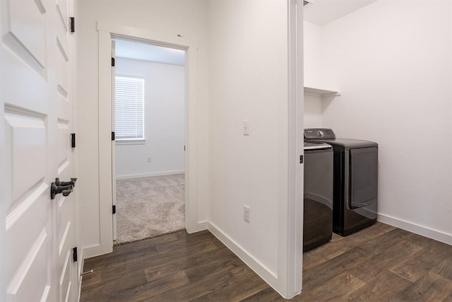 clothes washing area with washing machine and clothes dryer, laundry area, baseboards, and dark wood-type flooring