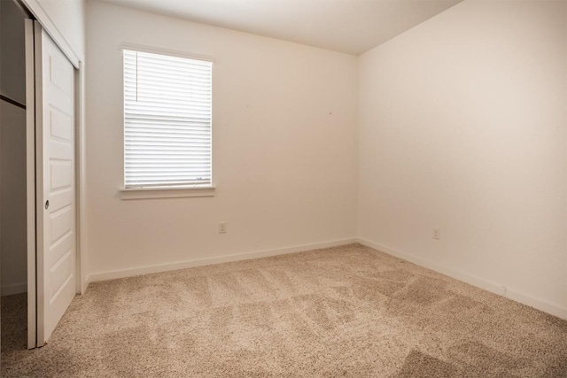unfurnished bedroom with carpet floors, baseboards, and a closet