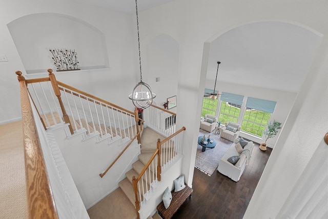 10700 Galsworthy Ln, Austin, TX 78739 - stairs featuring an inviting chandelier, arched walkways, baseboards, and wood finished floors
