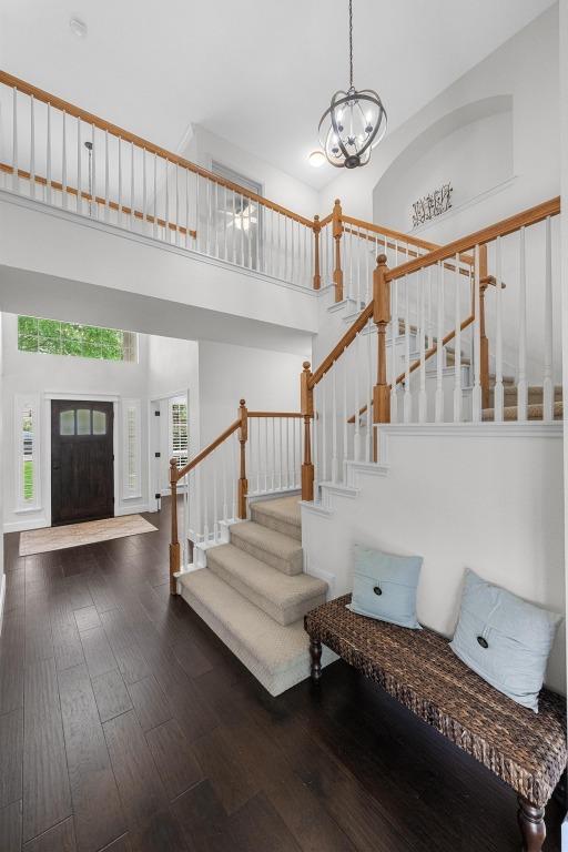 10700 Galsworthy Ln, Austin, TX 78739 - foyer entrance featuring a notable chandelier, stairs, wood finished floors, and a towering ceiling