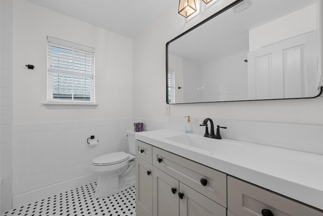 10700 Galsworthy Ln, Austin, TX 78739 - full bath with vanity, visible vents, wainscoting, toilet, and walk in shower