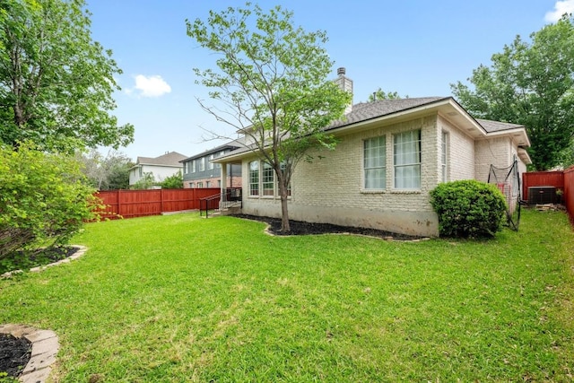 10700 Galsworthy Ln, Austin, TX 78739 - rear view of property featuring fence, brick siding, central AC unit, a chimney, and a yard