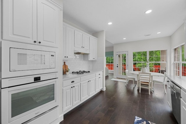10700 Galsworthy Ln, Austin, TX 78739 - kitchen with light countertops, dark wood-style flooring, white cabinets, and white appliances