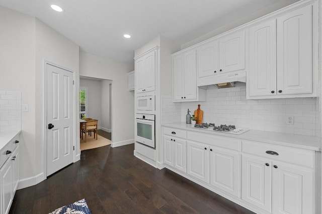 10700 Galsworthy Ln, Austin, TX 78739 - kitchen with light countertops, baseboards, under cabinet range hood, white appliances, and white cabinetry