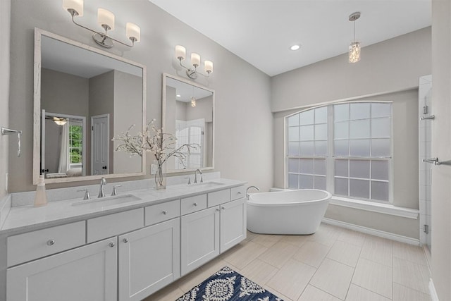 10700 Galsworthy Ln, Austin, TX 78739 - full bath featuring a sink, a freestanding tub, baseboards, and double vanity