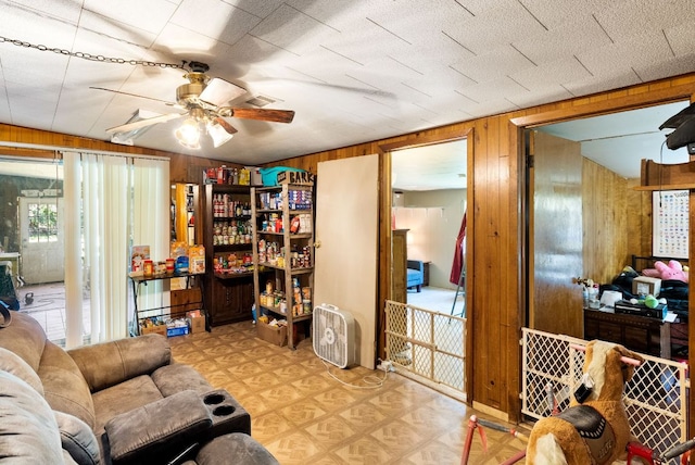 520 Munson St, Tow, TX 78672 - living area featuring visible vents, ceiling fan, tile patterned floors, and wooden walls