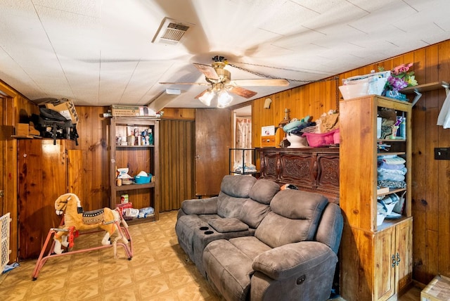 520 Munson St, Tow, TX 78672 - living area with tile patterned floors, wood walls, ceiling fan, and visible vents