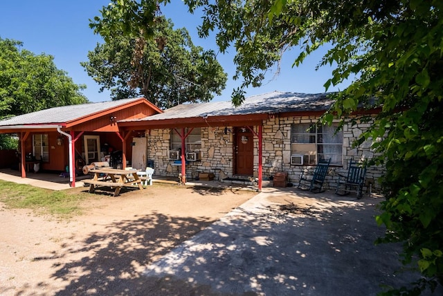 520 Munson St, Tow, TX 78672 - rear view of property with cooling unit, a patio area, stone siding, and metal roof